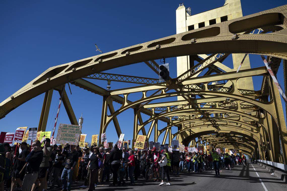 Members of the Natomas Teachers Association and Twin Rivers United Educators march across Tower Bridge in Sacramento on Thursday as a part of their strike against their respective districts.