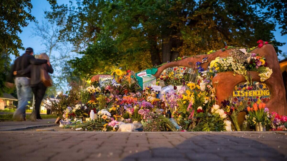 A couple walks by a the memorial for David Henry Breaux at Compassion Bench at Central Park in Davis, as night falls Wednesday, May 3, 2023, after three stabbings in the city in less than a week. Breaux was found fatally stabbed on April 27.