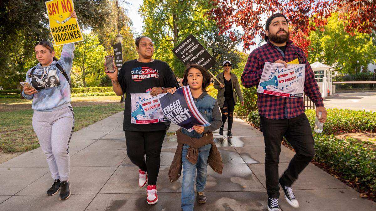 Nine-year-old Irah Arellano, center, of Gridley leads a group of marchers at the state Capitol, accompanied by his father Miguel, right, on Monday, Oct. 18, 2021. Thousands participated in a Keep Your Kids Home From School rally organized on social media by two Placer County mothers.