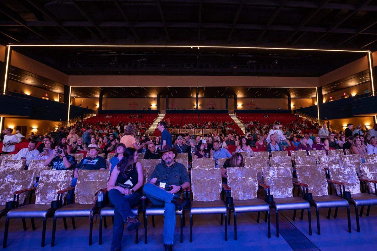 Shannon Sweeney, left, of Yuba City, and Vic Steele, of Orange, get situated in the front row at the internal VIP grand opening of the Hard Rock Live venue featuring country music star Tyler Rich on on May 26.