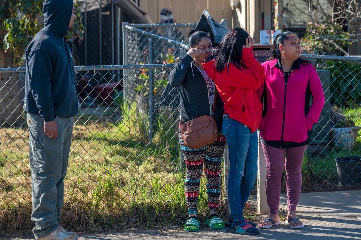 Vera Cruz, left, and Lizbeth DeJesus, center, wipe tears alongside Ana DeJesus, right, after placing a stuffed rabbit, white balloons and flowers at a memorial outside The Church in Sacramento on Wyda Way in Arden Arcade on March 1.