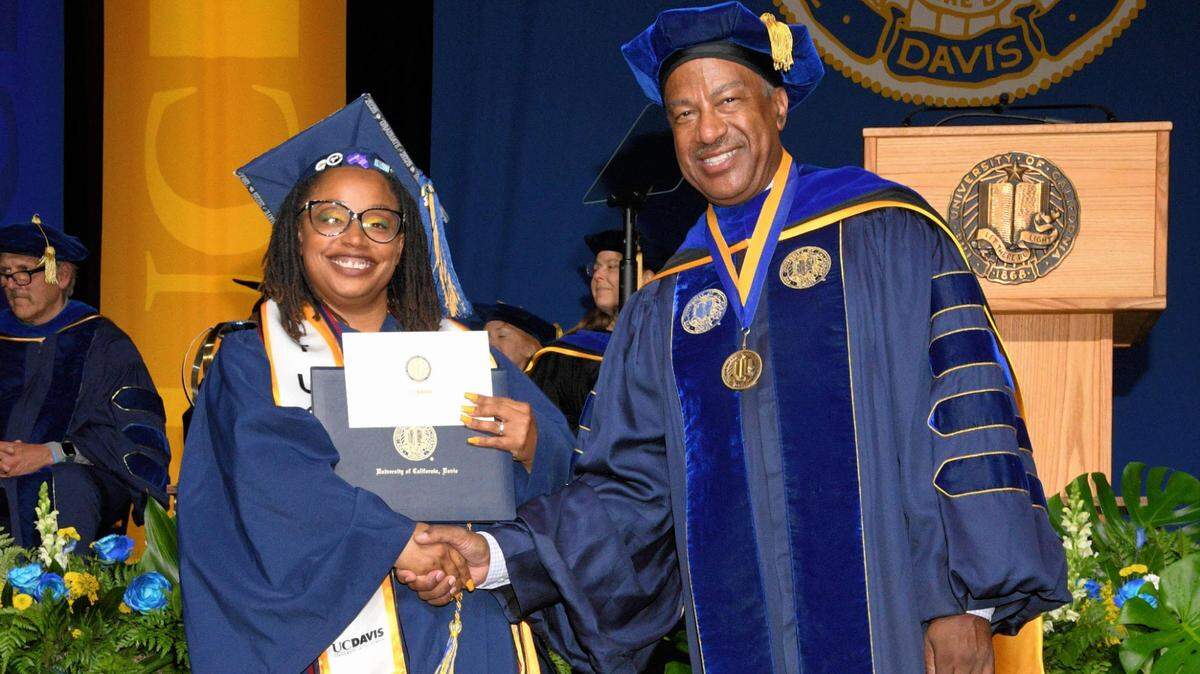 UC Davis graduate Laurin Williams shakes hands with UC Davis Chancellor Gary May.