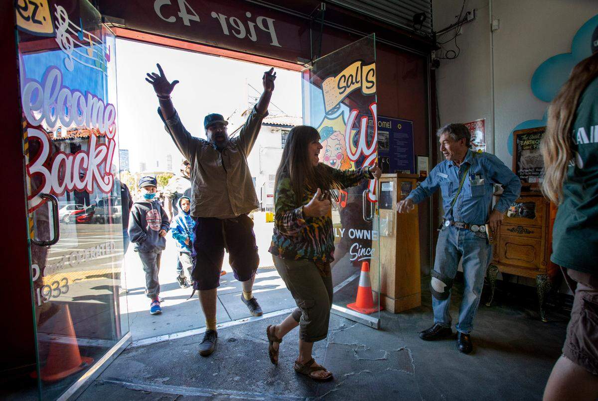 SAN FRANCISCO, CALIFORNIA - JUNE 15: Bear Bryan raises his arm in joy as Dan Zelinsky open the doors to his Musee Mecanique on the grand reopening day at Fisherman’s Wharf in San Francisco, Calif., Tuesday, June 15, 2021. Zelinsky’s beloved arcade closed fifteen months age when the pandemic shutdown began. (Karl Mondon/Bay Area News Group)