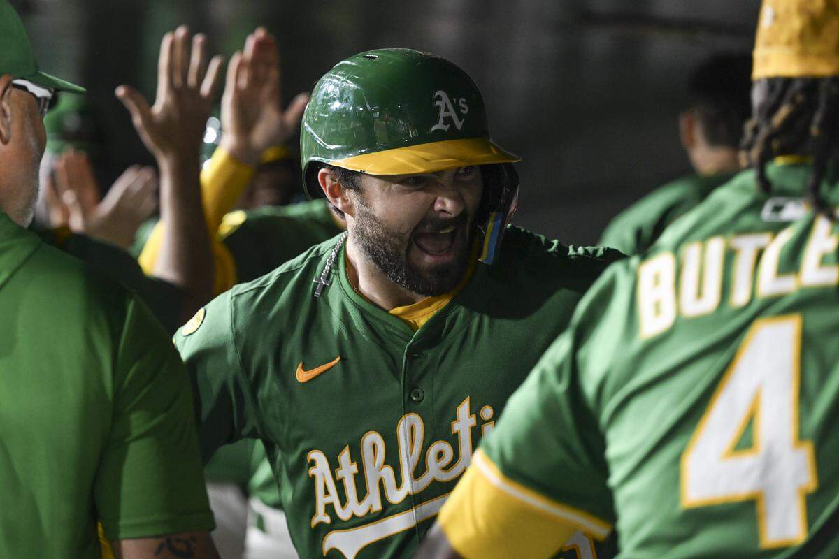 Athletics catcher Shea Langeliers (23) high fives his teammates after scoring a grand slam during a game against the Detroit Tigers at Sutter Health Park in Sacramento on Monday.
