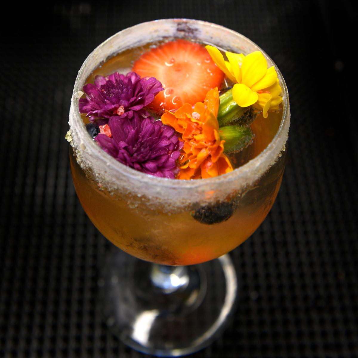 “That’s Pretty,” a drink made of seasoned fruit, edible flowers, peach syrup, lemongrass syrup, zesty cock with bull ginger beer with citrus sugared rum is served at The Morning Fork on Monday, Sept. 30, 2019.