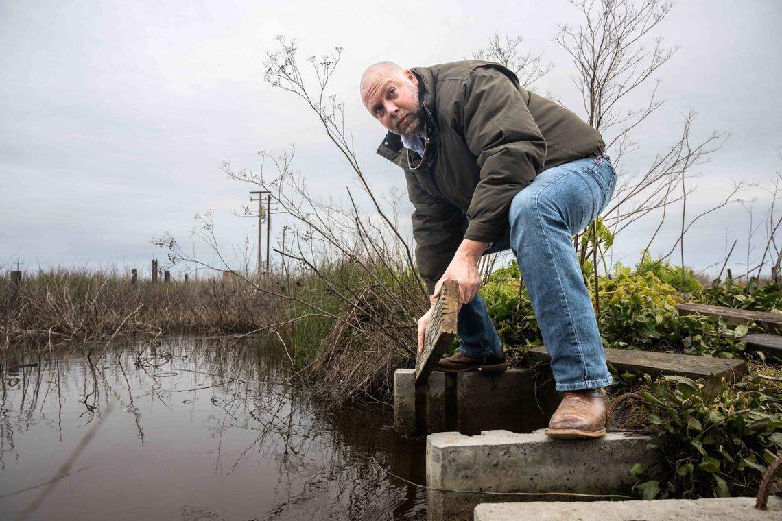 Matt Kaminski, a regional biologist with Ducks Unlimited, demonstrates how water is controlled during a wetlands tour last month at the Grasslands Wildlife Management area near Gustine.