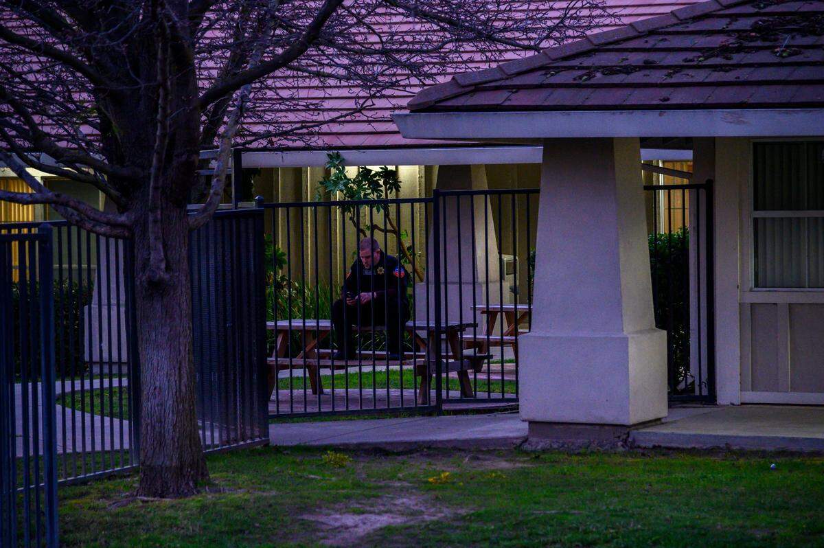 A security guard sits on a picnic table inside the fence at the Children’s Receiving Home in Sacramento in January.