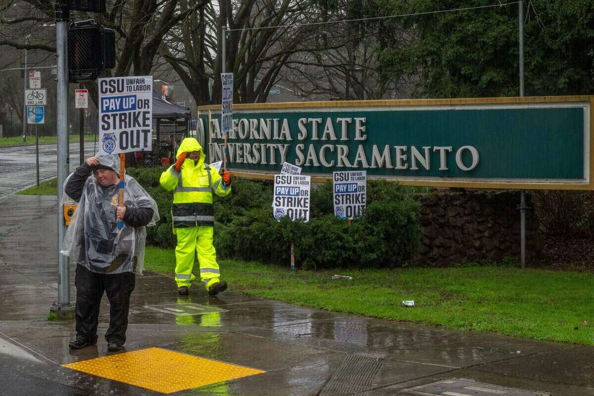 Avery Schick, left, a worker in facilities maintenance at Sacramento State's residence halls, joins a Teamsters Local 2010 stike on Tuesday in Sacramento.