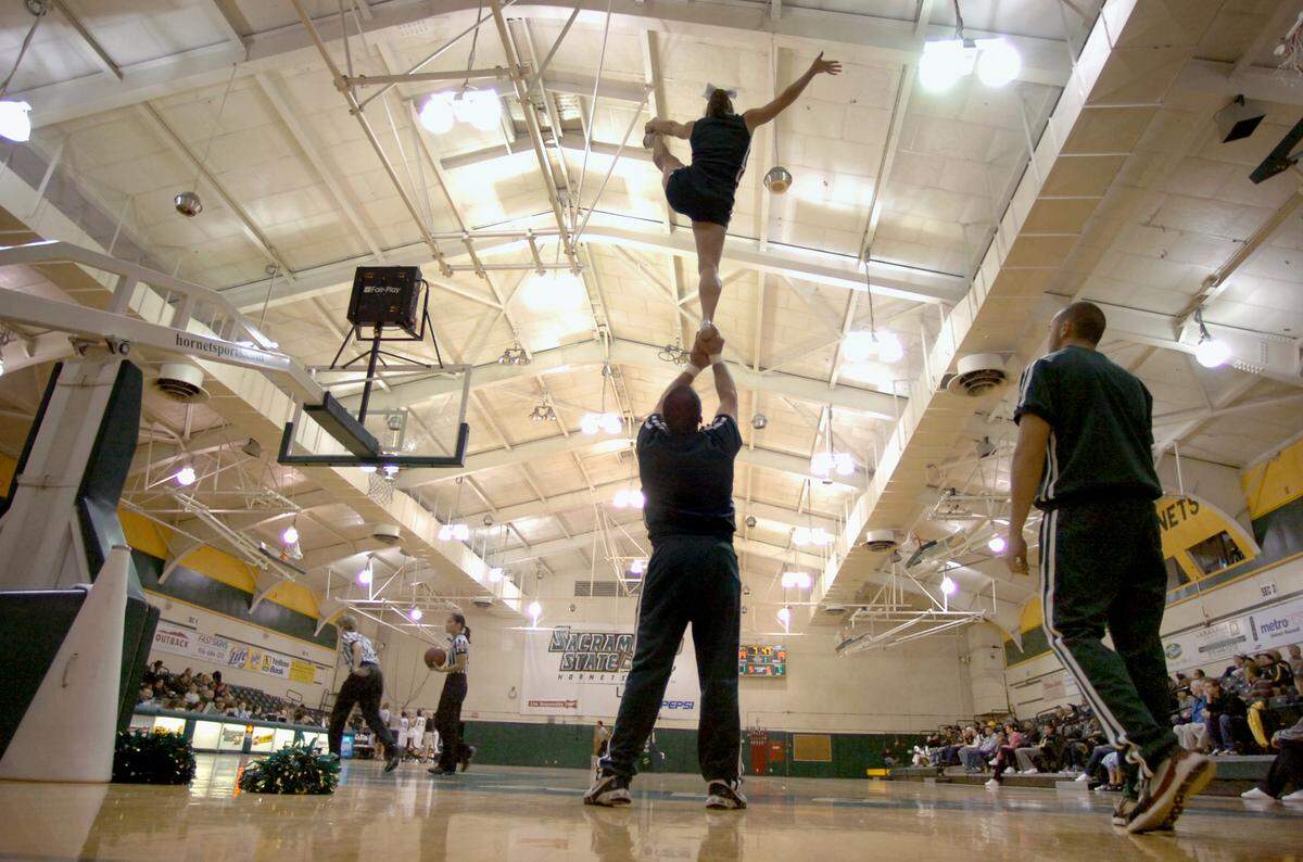 CSUS cheerleaders do a stunt during a time-out at a women’s basketball game in the Hornets Nest gym in 2008. For years, there has been talk of renovating the small, outdated gym or building an on-campus arena.
