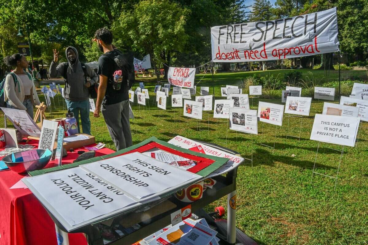 Sacramento State senior Saniel Engotto, center, chats with students at a protest art installation on the Library Quad on Thursday. Titled “Free Speech Doesn’t Need Permission,” the art installation was organized by students and faculty to protest the California State University system’s new time, place and manner policy that places limits on protests.