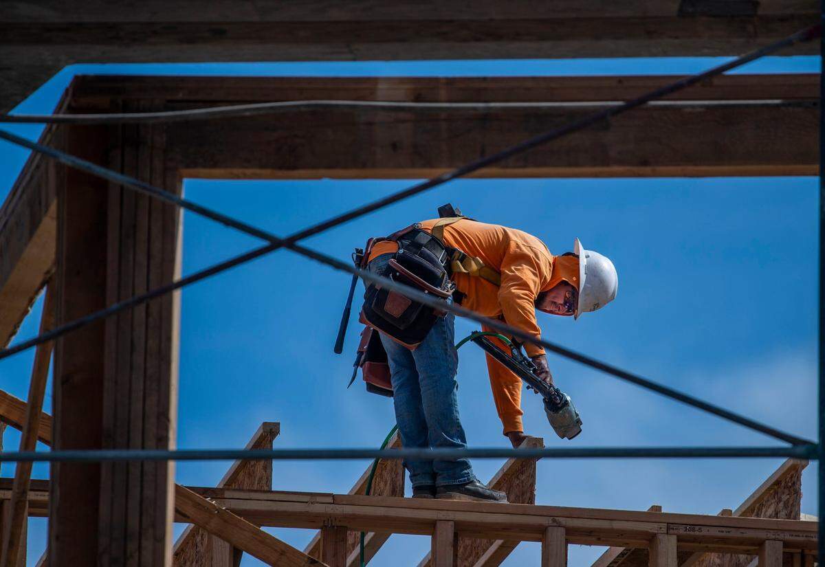 A worker frames a building Wednesday at Mirasol Village. The affordable housing project, which broke ground in 2020, had federal and state funding.