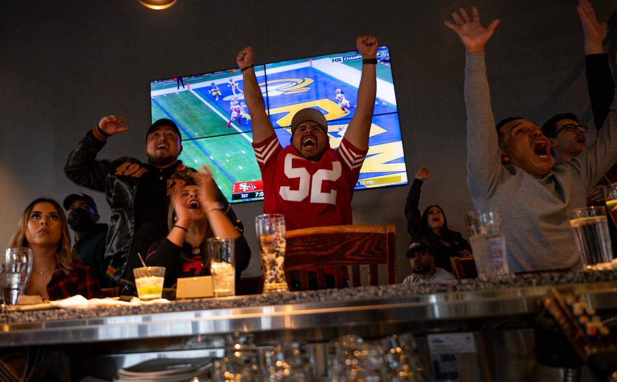 Alejandro Reyes (52) and other customers cheer in 2022 at Public House Downtown in Sacramento as the San Francisco 49ers play the Los Angeles Rams in the NFC Championship.