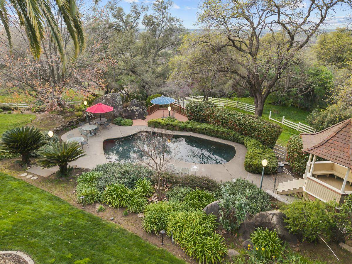 At 7257 Surrette Lane near Loomis, a resort‑style pool, tennis court, koi pond, and fenced pasture with barn turn the three‑acre property into a private estate designed for both entertaining and everyday country living.