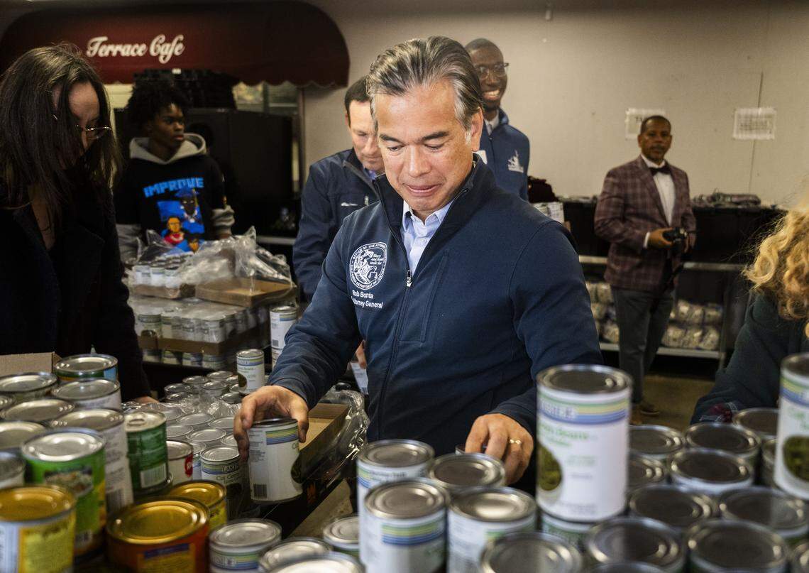 California Attorney General Rob Bonta helps sort food at an AmeriCorp food pantry at Natomas High School in Sacramento on Tuesday. Bonta helped defend the AmeriCorps organization from budget cuts by the Trump administration.