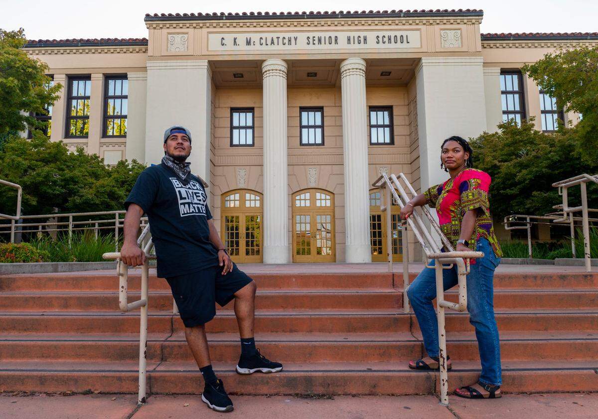 C. K. McClatchy High School teachers Luis Guerrero, left, and Dominique Williams stand in front of their school in Sacramento on Monday, Aug. 3, 2020. Williams and Guerrero started anti-racism seminars for the faculty and staff to teach others to think about institutional racism and ways they can combat it to make life better for their students.