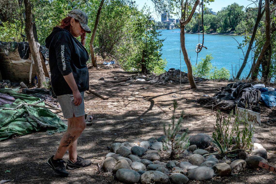 Twana James wipes tears in June as she stands before a grave where her dog “Yogi Bear” is buried at a pet cemetery near their camp.