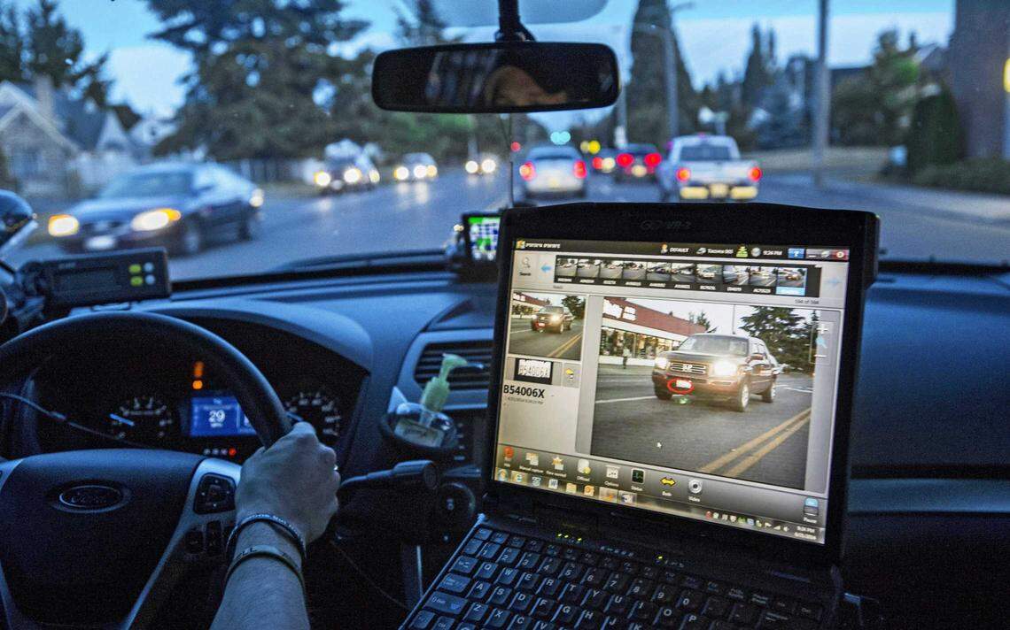 A police officer in Tacoma, Washington, monitors data from a car-mounted automatic license plater reader in 2014. 