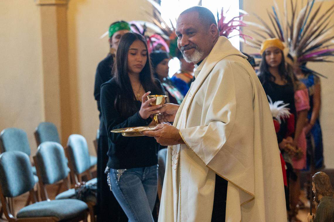 The Rev. Nelson Rabell-González, pastor of Iglesia Luterana Santa María Peregrina church in Stockton, gives communion.