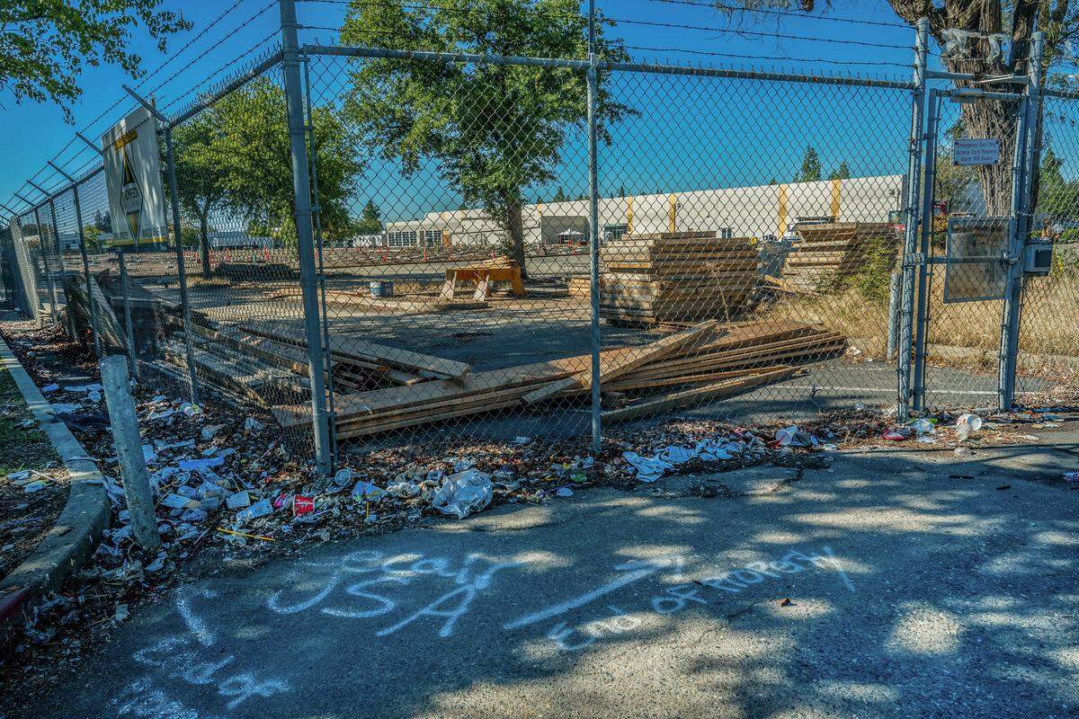 Construction materials rest inside a fence on Oct. 16, 2025, in the parking lot of a former call center at 4837 Watt Ave. in North Highlands, which is being converted into a homeless shelter. At $65 million, it will be the most expensive shelter to open in Sacramento County history.