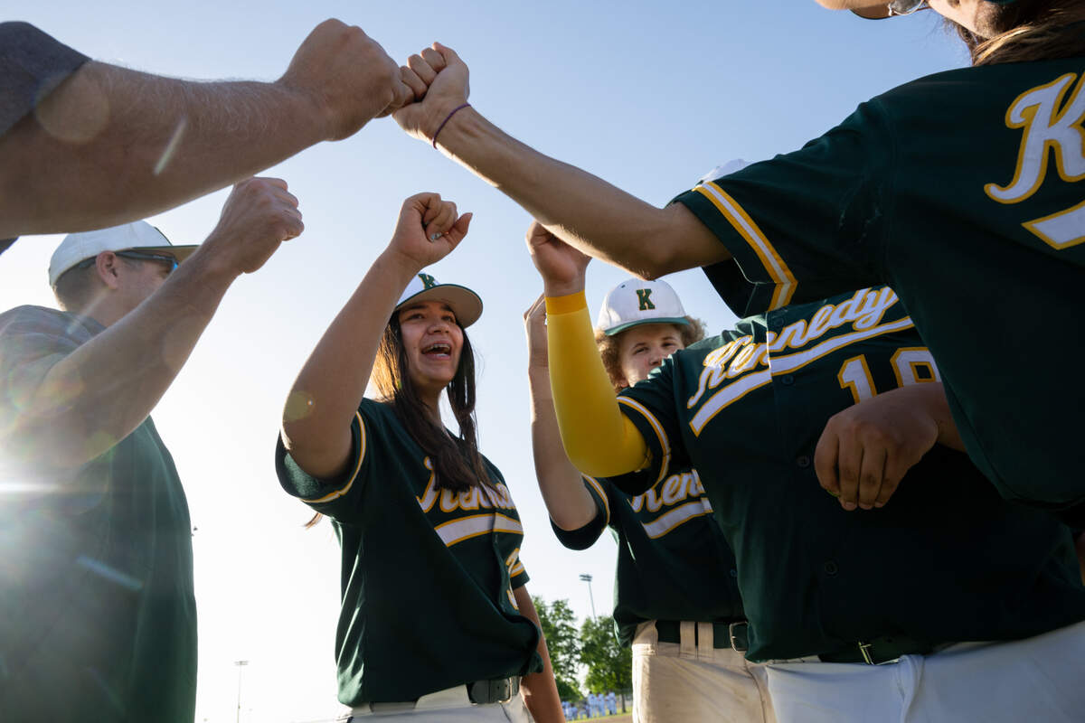 Kennedy Cougars team captain Laney Fukuoka bumps fists with teammates after a game against the Antelope Titans on Monday. Fukuoka pitches and plays first base on the varsity baseball team.