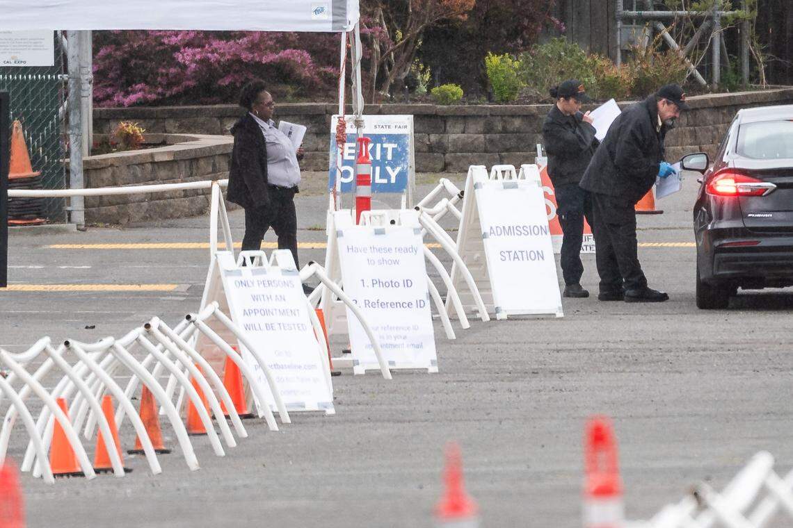 People pull their vehicles up to a checkpoint with signage for testing at CalExpo on Tuesday, March 24, 2020, in Sacramento.