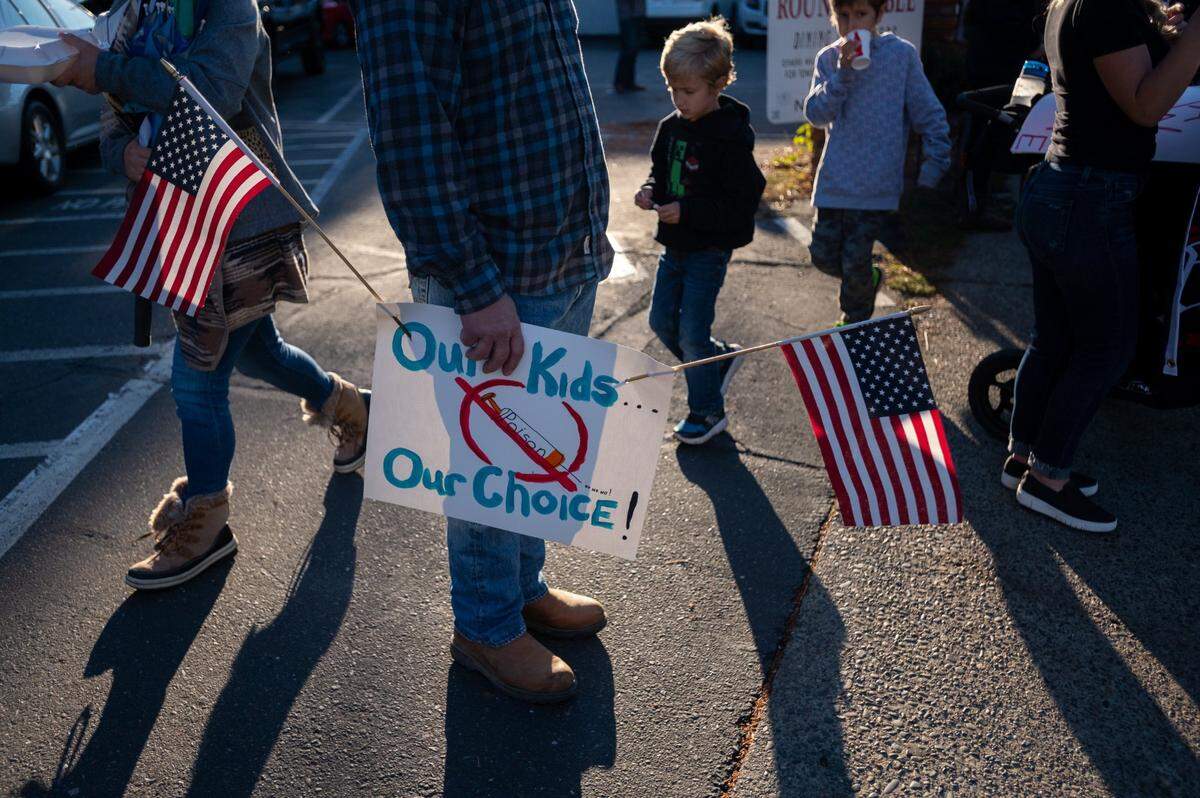 Children walk past a protester with a sign that reads “Our Kids Our Choice” during the Rally Against Vaccine Mandates in front of the El Dorado County Superior Court on Oct. 18, in Placerville.