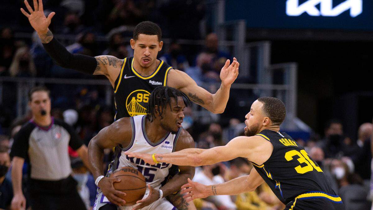 Golden State Warriors forward Juan Toscano-Anderson (95) and guard Stephen Curry double-team Sacramento Kings guard Davion Mitchell (15) during the fourth quarter of an NBA basketball game, Thursday, Feb. 3, 2022, in San Francisco. The Warriors won 126-114. (AP Photo/D. Ross Cameron)