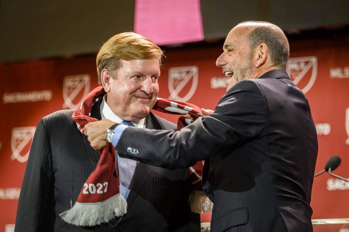 MLS Commissioner Don Garber wraps a scarf around Sacramento Republic FC owner Ron Burkle after announcing that Sacramento would get the league’s 29th franchise at The Bank in downtown Sacramento, Monday, Oct. 21, 2019.