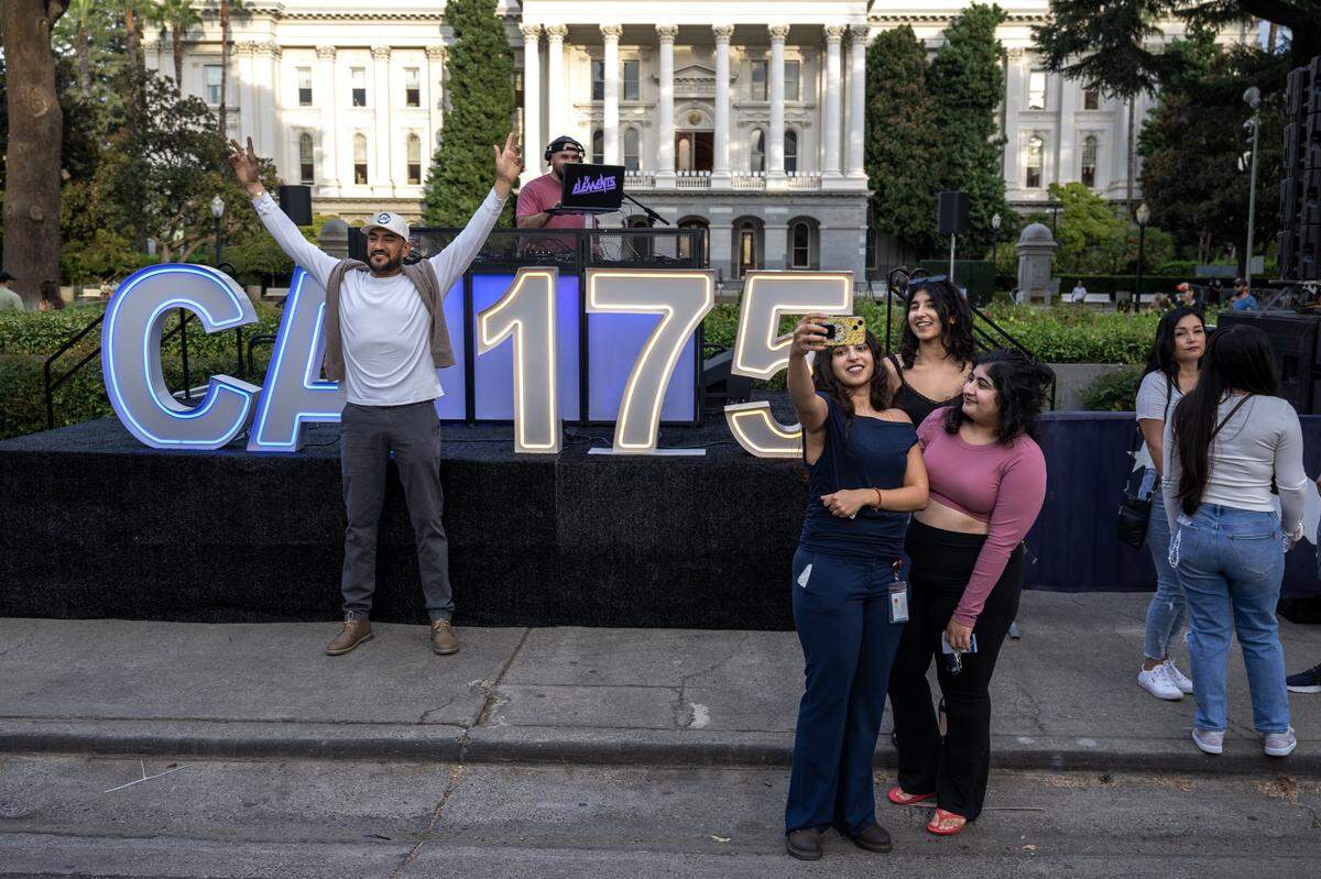 Sandy, Karya and Sunny Ahuja take a selfie while Juan Flores poses for a photograph during a 175th birthday block party to celebrate California's anniversary of statehood on Tuesday, Sept. 9, 2025, at the state Capitol.