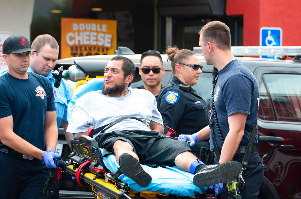The carjacking suspect is taken on a stretcher to an ambulance in the parking lot of the Del Taco on Alhambra Boulevard on Friday.