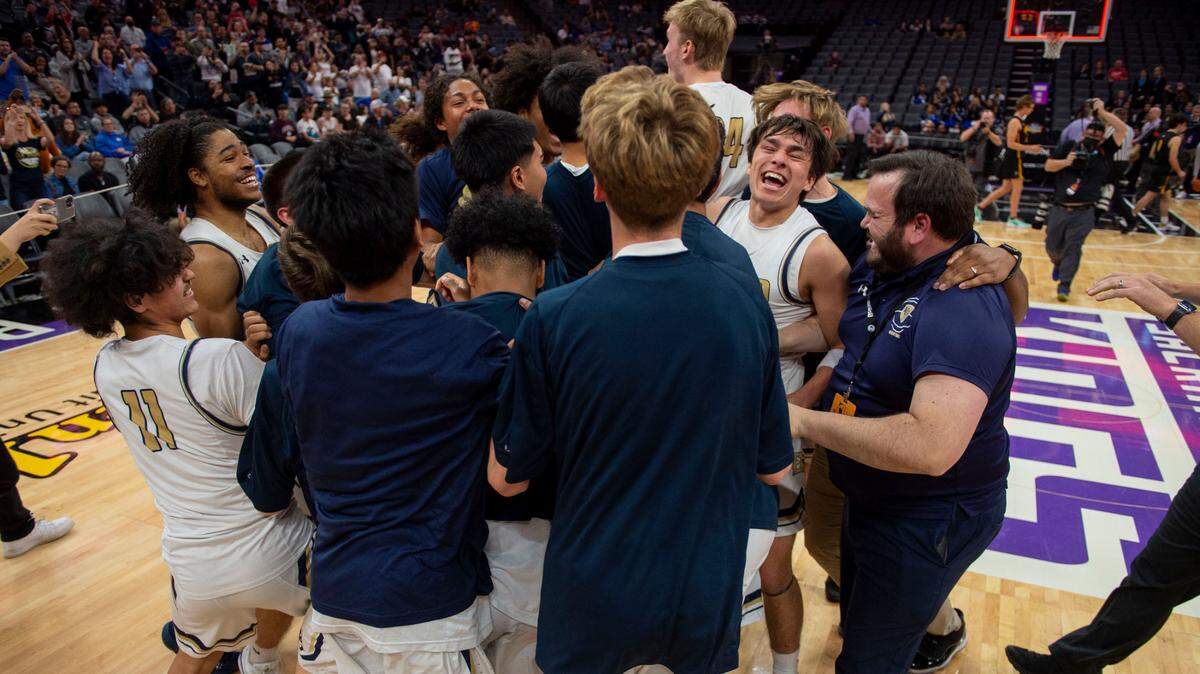 Elk Grove players celebrate with head coach Dustin Monday, right, after winning in the school’s first state title in the CIF state Division II championship game against Foothill of Santa Ana on Saturday at Golden 1 Center.