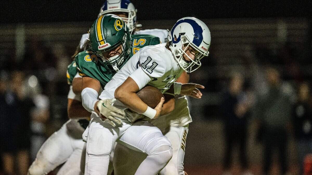 The Placer Hillmen’s Ivan De Silva (75) tackles Casa Roble Rams quarterback Aidan Lopez (11) in Auburn during the 2024 season opener for both teams.