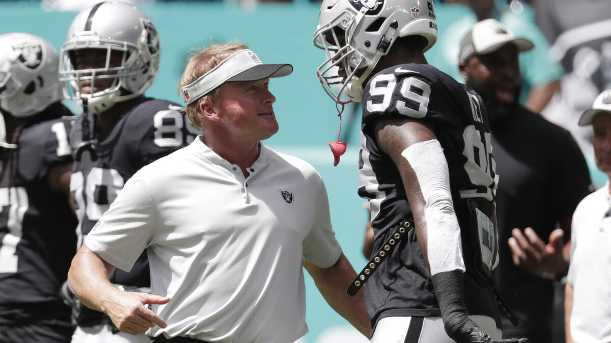 Raiders head coach Jon Gruden talks with defensive end Arden Key before Sunday’s game against the Miami Dolphins in Miami Gardens, Fla.