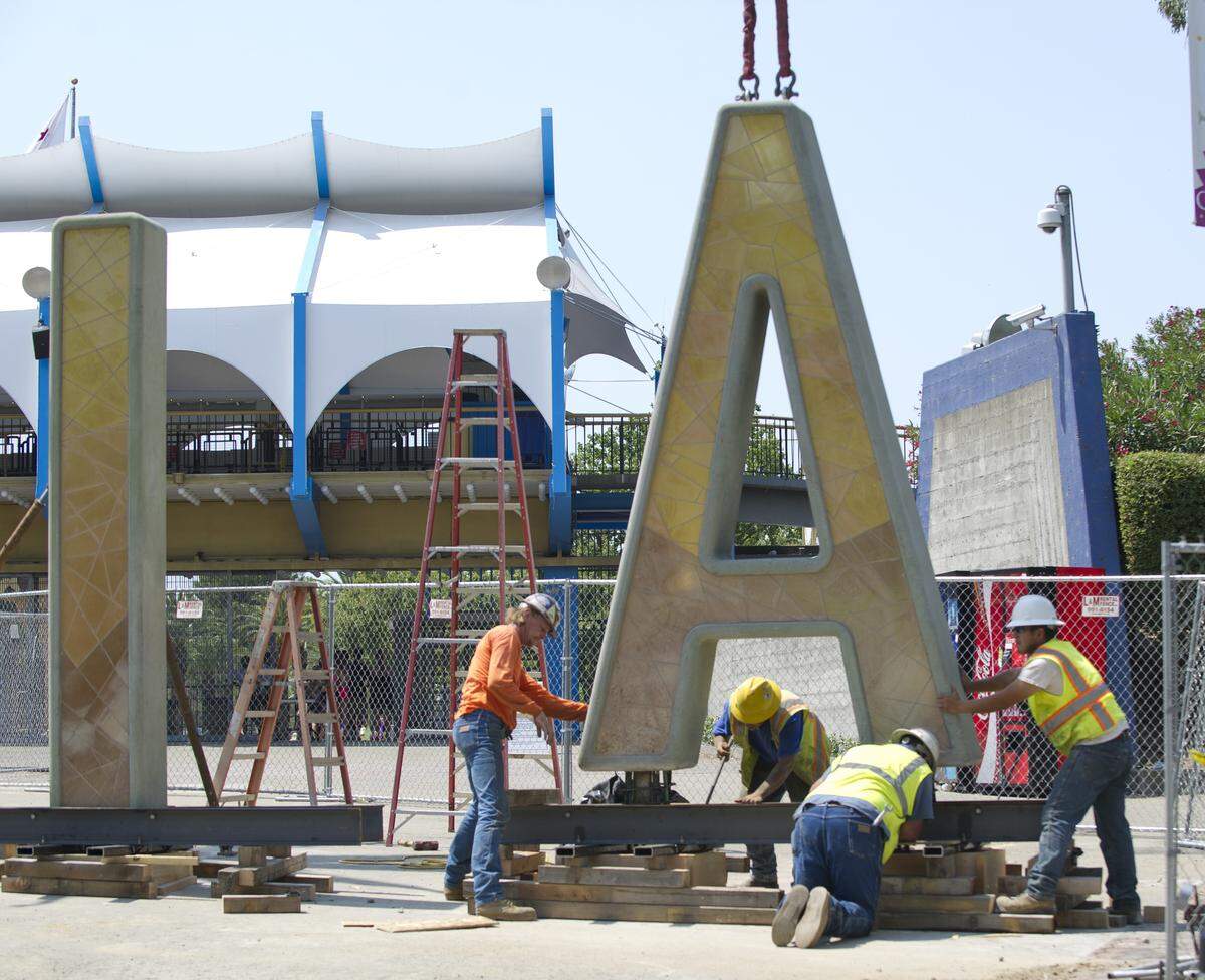 A construction crew installs the Disney C-A-L-I-FO-R-N-I-A letters at the main gate of Cal Expo on July 1, 2013, in Sacramento. The letters stood at the entrance of Disney's California Adventure park in Anaheim for a decade.