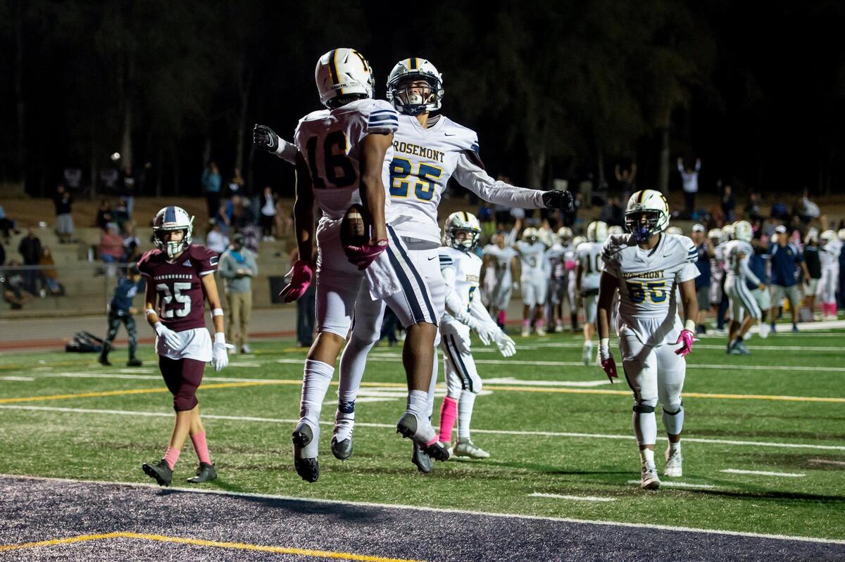Rosemont’s Finis Mcdaniel jr. (16) celebrates with Jose Rocha (25) after scoring a touchdown during the fourth quarter in the game Friday at Union Mine High School in El Dorado. The Wolverines won 27-12.