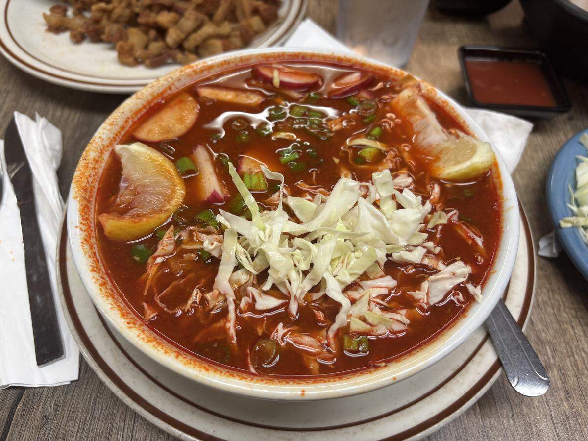 A bowl of red pozole at La Placita in Orangevale comes with nixtamalized corn kernels called hominy, bite-sized cubes of tender pork, shredded cabbage, sliced radishes and chopped green onions submerged in the savory chile-based broth.