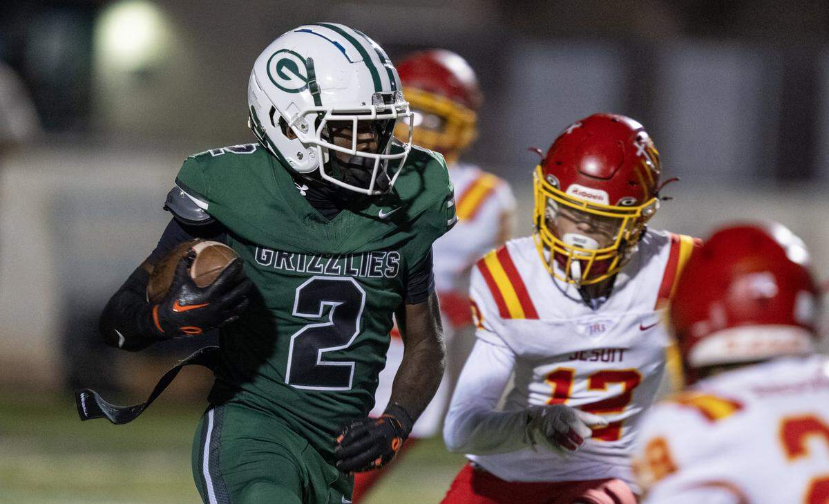 The Granite Bay Grizzlies' Darnell Turner (2) runs through the the Jesuit Marauders' defense in the second half Friday in Granite Bay.