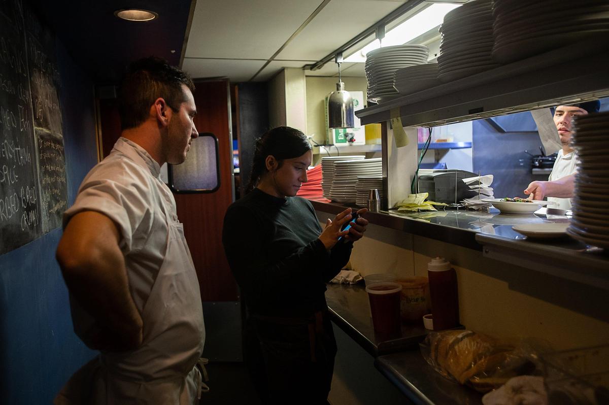 Executive Chef Anthony Scuderi talks with food runner Alex Avalos in the kitchen at Hook & Ladder Manufacturing Co. on March 22.