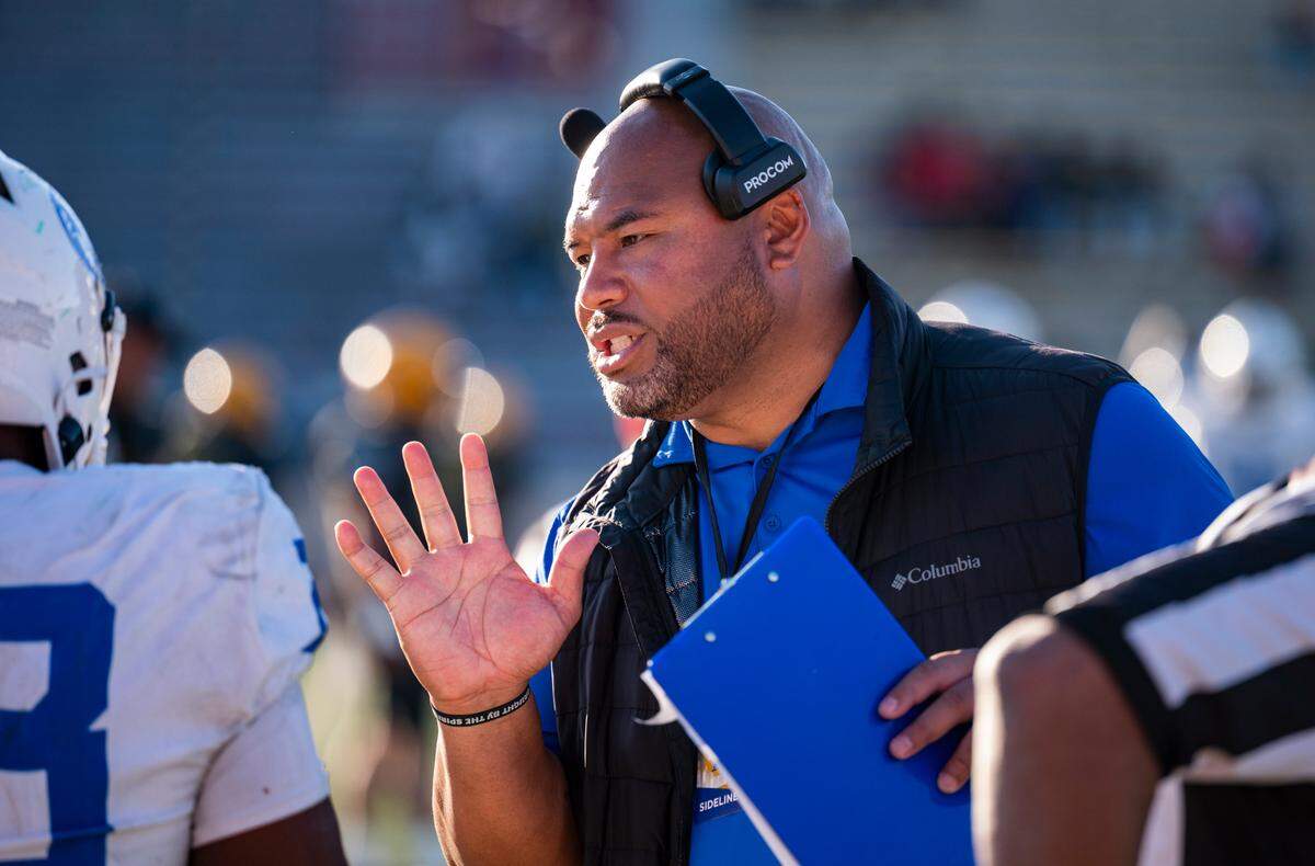 Capital Christian coach Saul Patu gives instructions to a player after a late hit penalty in the fourth quarter of the CIF Sac-Joaquin Section Division IV championship football game at Hughes Stadium in Sacramento on Saturday.
