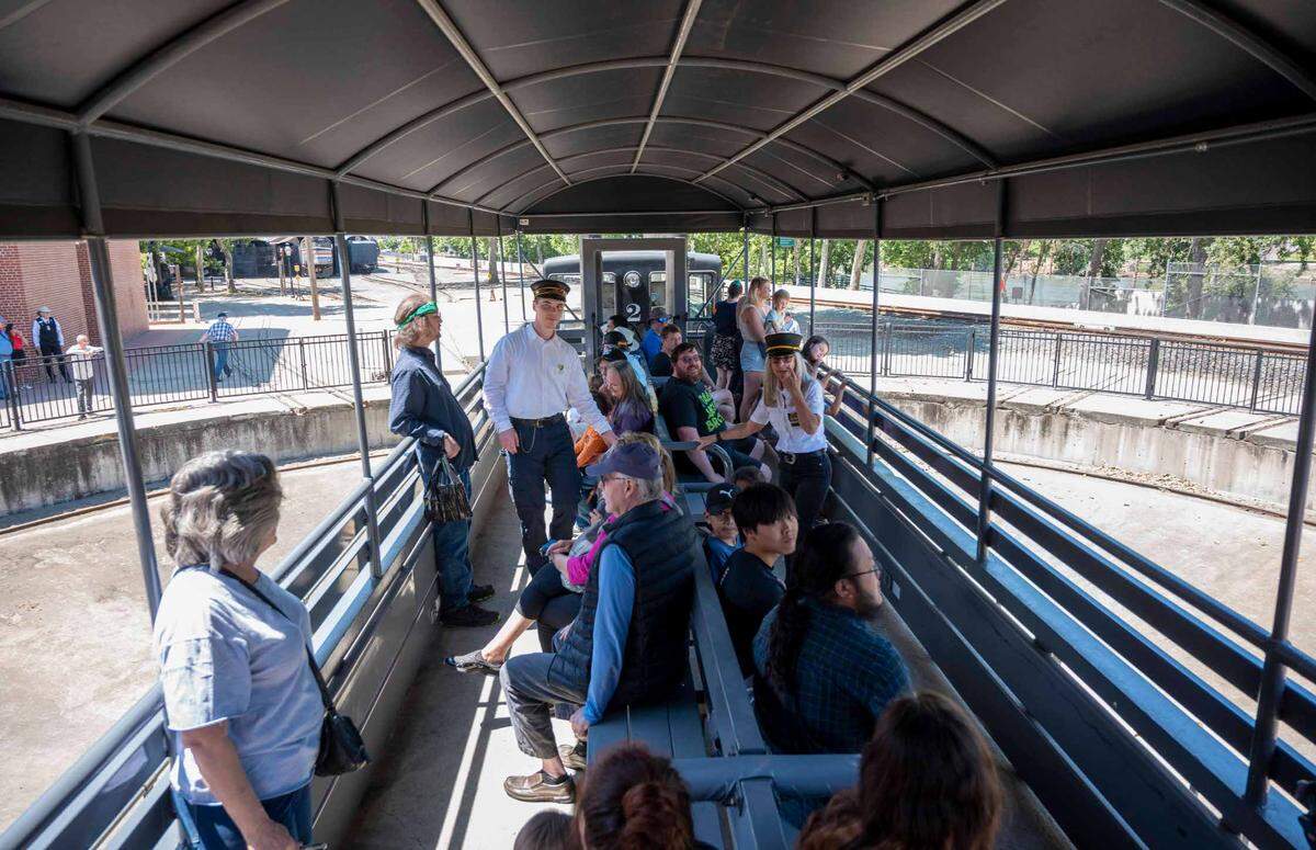 Passengers sit on a train that turns on the California State Railroad Museum’s historic turntable, originally built in 1911, Wednesday in Old Sacramento. The No. 2 locomotive pulled an open-air gondola for 15-minute train rides that included a few spins on the turntable.