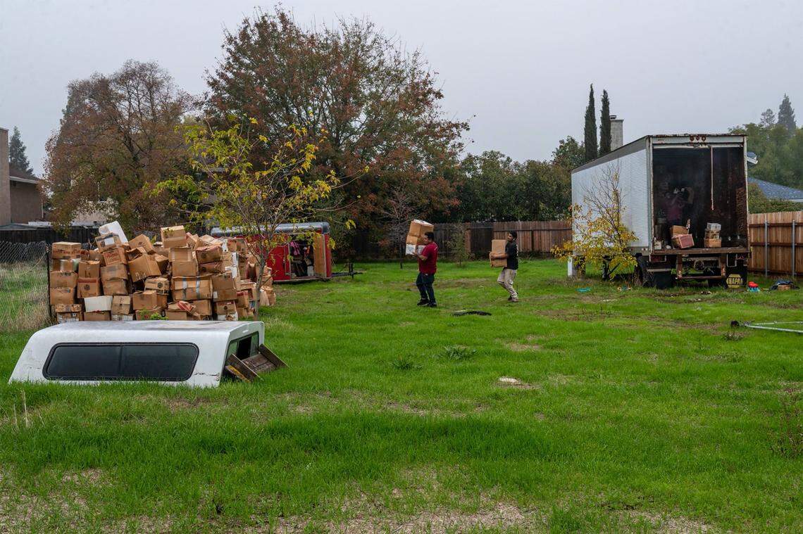 Crews for a court-appointed receiver remove the contents from two storage trailers as they prepared to tow them from Mark Melton’s backyard on Nov. 12. Melton said they were only able to drag the smaller trailer out of the yard, and they left all the boxes outside, unprotected from the rain, after they were unable to tow the larger trailer.