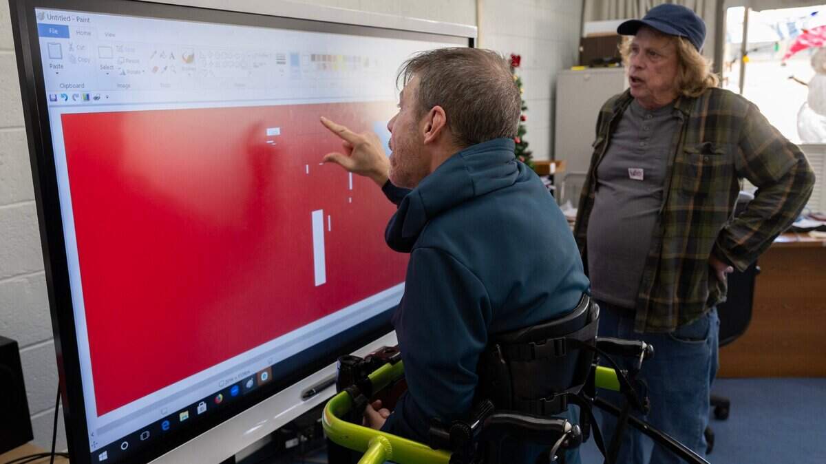 Adam Badger creates artwork on an interactive screen with art teacher Jim Mansfield on Monday, Dec. 9, 2024, at UCP of California, an adult day care program for people with disabilities in Foothill Farms. The program hopes to purchase another screen and stand with funding from The Book of Dreams.