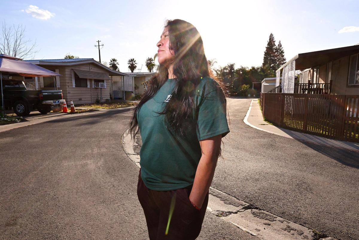 Xochilt Nuñez, who immigrated from Mexico in 1999, stands in the street at her mobile home park in Orosi, a small community in Tulare County, on Tuesday, March 26. Nunez has spent years advocating for farmworker and immigrant&nbsp;rights and yet describes frustration and anger with the recent waves of migrants.