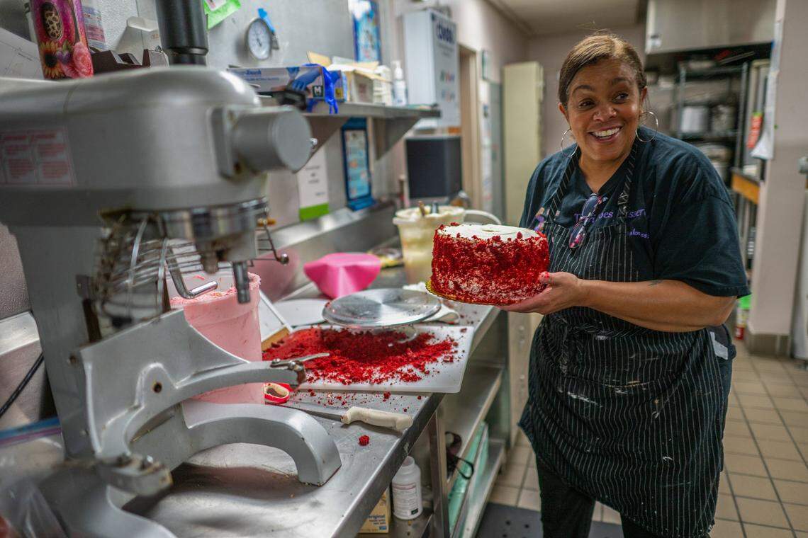 Terri Littleton, 63, a self-employed owner of Terri Does Desserts, carries a red velvet cake she had just iced in an industrial kitchen in Sacramento on Wednesday, April 1, 2026. Although the baker struggles to pay for her healthcare as a single business owner, she said she tries to maintain a positive outlook on life.