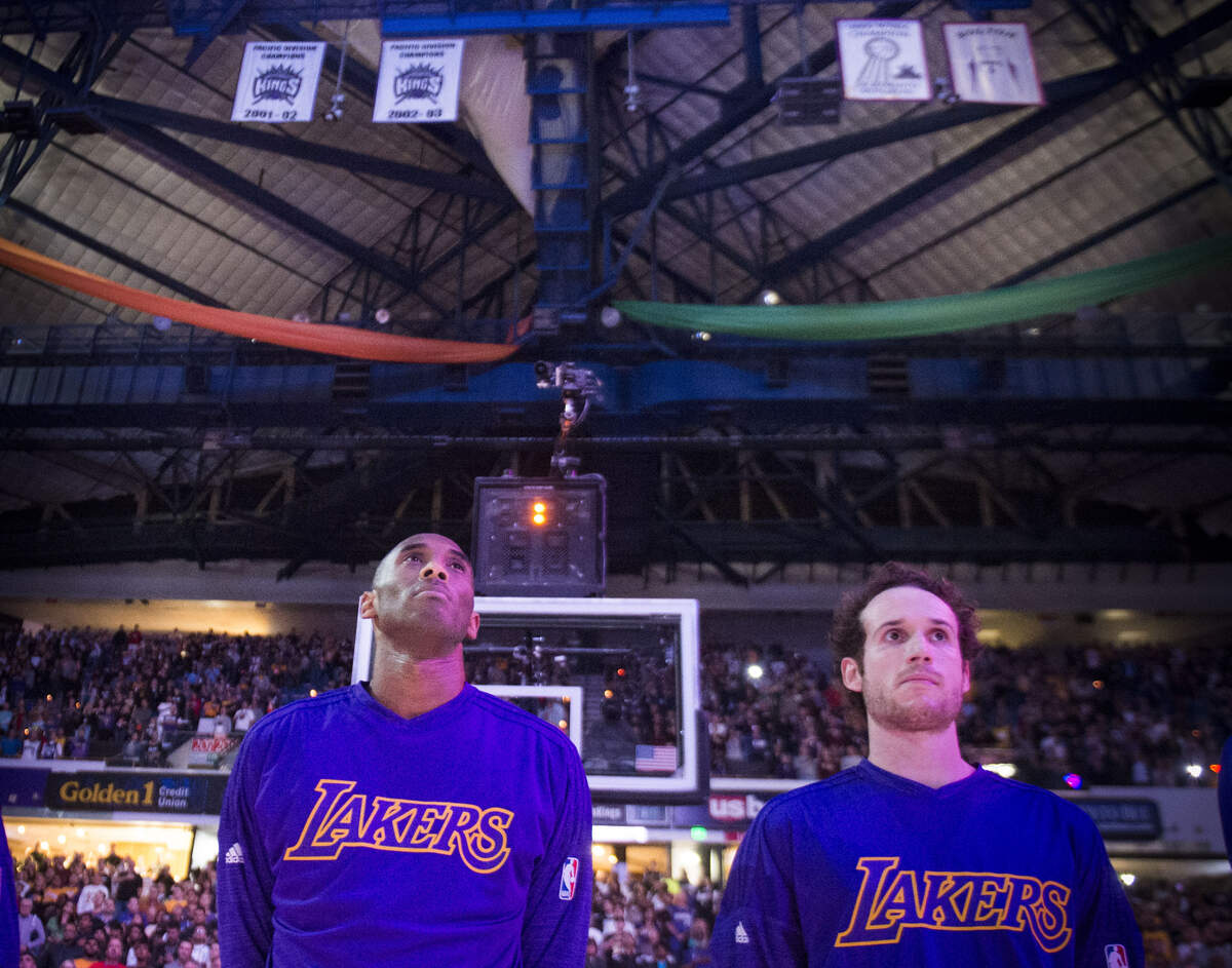 Los Angeles Lakers forward Kobe Bryant (24) stands for the national anthem for the last time at Sleep Train Arena against the Sacramento Kings as their championship banners hang behind him.