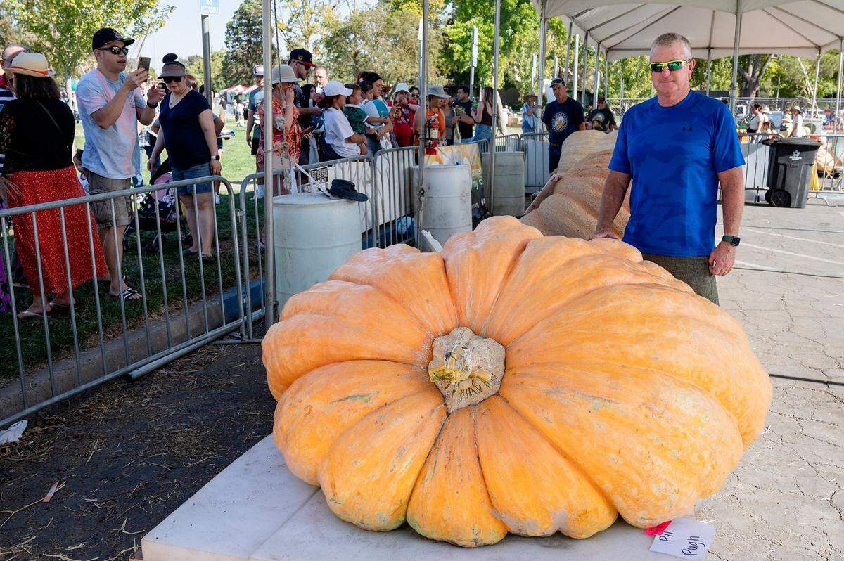 Russ Pugh poses with his 1,941-pound winning pumpkin at the Elk Grove Giant Pumpkin Festival on Sunday. Pugh previously won first place in 2014.