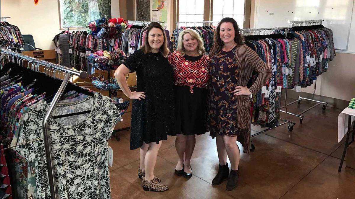 Chris Jacobs, center, stands with other LuLaRoe retailers and her inventory during her first open house show in 2017. Jacobs would rent out facilities with other consultants to sell the clothes.