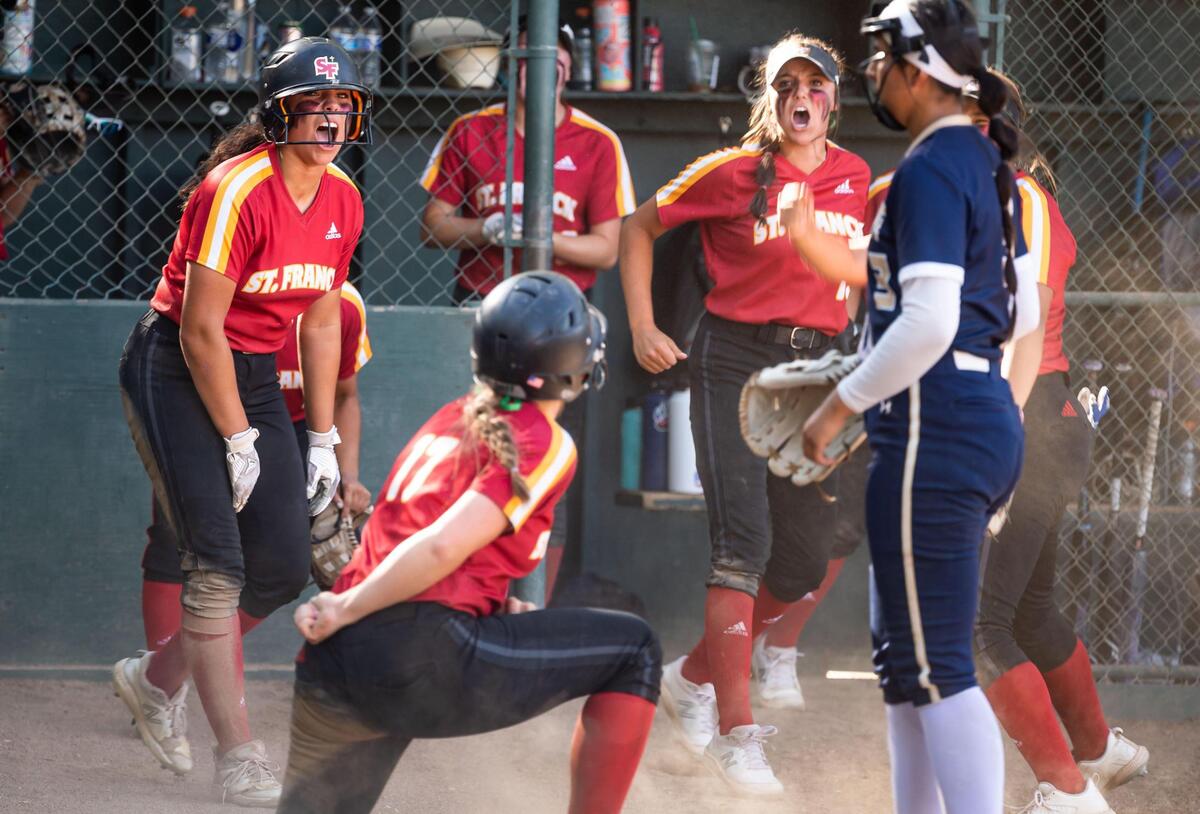St. Francis’ Olivia McFarland, left, scores and cheers while Grace Jenkins scores an additional run off a double by Hope Jenkins during a fifth inning rally against Elk Grove at the Sac-Joaquin Section semifinal high school softball game Tuesday, May 24, 2022, at St. Francis Catholic High School in Sacramento.
