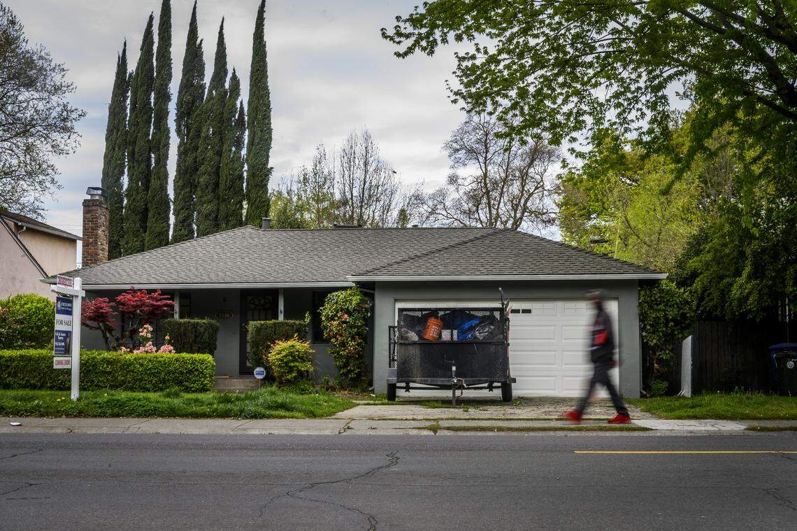A man walks past 2746 Muir Way in North Land Park in Sacramento on Tuesday, March 31, 2020. Sacramento police removed three homeless adults on Sunday who had been living in the home, which is owned by Wedgewood Inc., as a way to shelter in place during the coronavirus crisis.