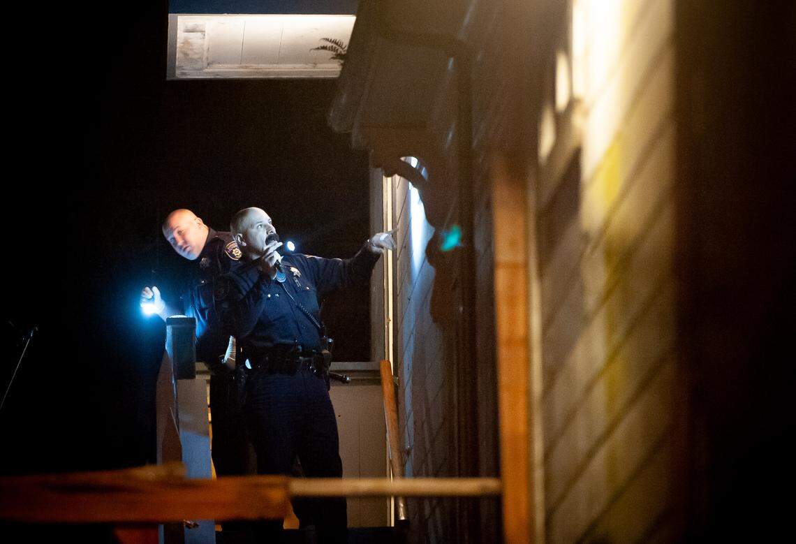 Eureka Police Sgt. Rodrigo Reyna-Sanchez, foreground, looks for evidence on the wall of a residence at the scene of a shooting in November 2015 in Eureka.